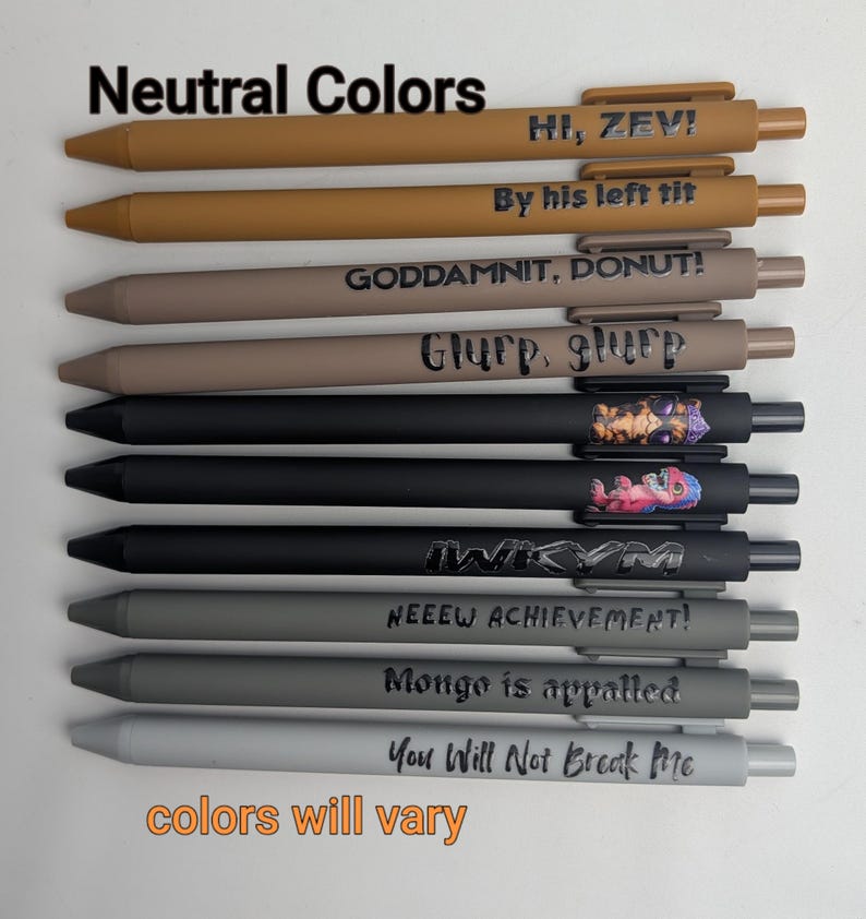 Puede incluir: Un juego de diez bol&iacute;grafos retr&aacute;ctiles en varios tonos neutros, incluyendo marr&oacute;n claro, beige, negro y gris. Cada bol&iacute;grafo presenta texto o gr&aacute;ficos impresos &uacute;nicos, como HI, ZEV!, By his left tit, GODDAMNIT, DONUT!, Glurp, glurp, IWIKYM, NEEEW ACHIEVEMENT!, Mongo is appalled y You Will Not Break Me.