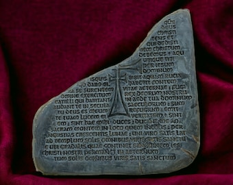 May include: A gray stone with a cross carved into it. The stone has an inscription in Latin, which reads: "squis DABO CL RA SE SURENTER OMINE EXERCITUM CATULLI qui HABITANT AUDANT TE IN SECULA TU DEUS ES MEUM TE TUAM LUCEM EL qurs DEUS CHRISTI TENS ET queDIST BEM CHRISTUS DEBEMUS + aqu UBIQUE TIBL PER LESUM DOMINIUM BIBIT Aquam Rucia DABEBIT FONTEM VITAE AETERNAE FUG REX OGORUM NOSTRU IN AEDE TUA Dominum SACCULORUM.sum REFUGIUM: EMIT VERITATE+ SINT GM: SINT hae mihi duces: ducante 20 SACRAM MONTEM IN LOCO QUEM INCOLIS: PER ANGUSTIAS CRESCENTIS LUNDE: UNI VIRO SATIS LAW Ad Templum SOLIS OMNIBUS VIRIS SATIS SANCTU E UBI GRADALIS QUAE CONTINET SANGUINEM Les CHRISTI NOSTRI PERMANET IN AETERNUM TUM Solis OMNIBUS VIRIS SATIS SANCTUM"