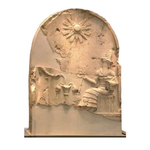 May include: A beige stone relief sculpture of a seated figure with a crown and a sun symbol above. The sculpture is damaged and has some missing pieces.