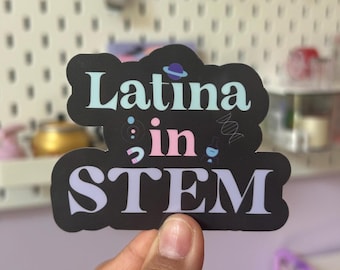 Może przedstawiać: Czarno-biała naklejka z tekstem "Latina in STEM" w kolorowym foncie. Naklejka zawiera małe ilustracje planety, probówki, nici DNA i zlewki.