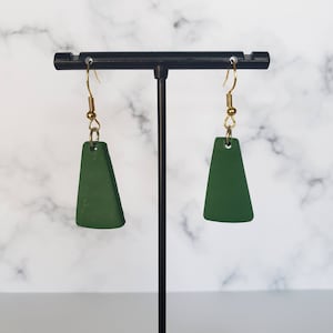 May include: A pair of green triangle-shaped dangle earrings with gold hooks.