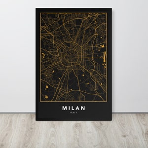 May include: A black and gold city map print of Milan, Italy. The map is framed in a black frame and the city name is written in gold letters below the map.