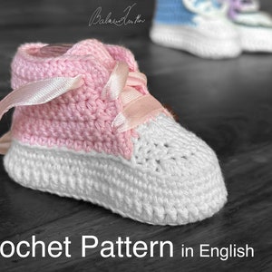 May include: A pink and white crocheted baby shoe with a pink satin ribbon. Crochet Pattern in English.