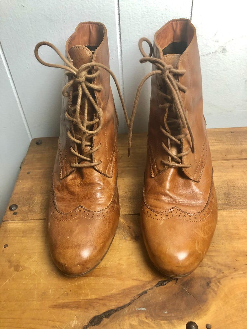 May include: A pair of brown leather lace-up ankle boots with a brogue design.