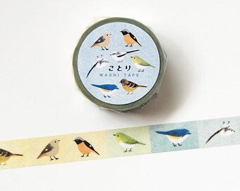 May include: A roll of washi tape with a light blue and green design featuring illustrations of various birds. The tape also has the Japanese text "ことり WASHI TAPE". A strip of tape is unrolled, showing more bird illustrations.