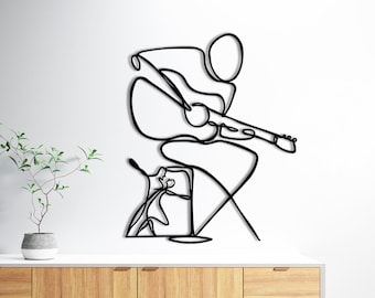 May include: Black metal wall art depicting a person playing a guitar. The art is in a minimalist line drawing style.