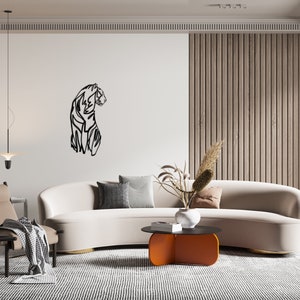 May include: A modern living room interior with a white sofa, a black and white line art tiger wall decor, a wooden slat wall, a black and orange coffee table, and a brown armchair with a throw blanket.