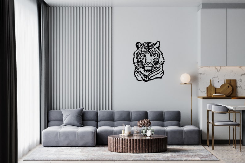 May include: A black and white line art illustration of a tiger's head, mounted on a white wall in a living room setting. The tiger's head is facing forward, with its mouth closed and its eyes open. The illustration is simple and elegant, and it would make a great addition to any home decor.