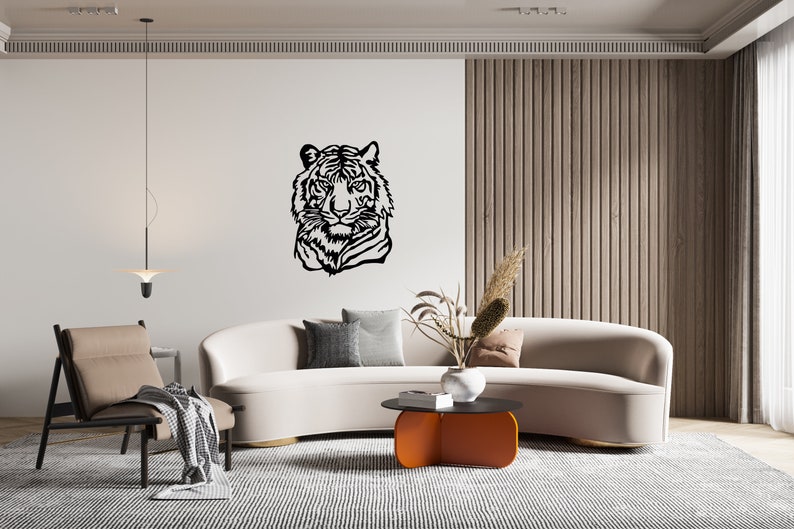 May include: A white curved sofa with a black and white tiger head silhouette wall decor, a brown armchair, a coffee table with an orange top, and a potted plant with dried flowers.