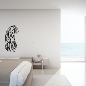 May include: A black and white line art illustration of a tiger on a white wall in a modern bedroom with a bed, a side table, and a window with a view of the sea.