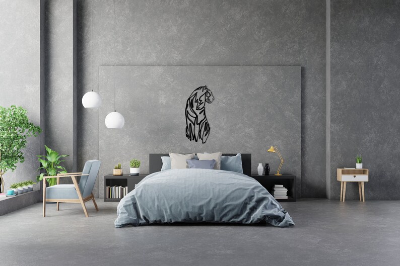 May include: A black metal wall decor featuring a stylised silhouette of a tiger. The decor is hanging on a grey wall above a bed with blue bedding.