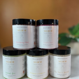 May include: Five glass jars of body scrub with black lids. The jars are labeled "Sugar Me Body Polish" with different scents: Strawberry Mint, Vanilla Rose, Coconut Lime, Gingerbread & Pumpkin, and Tea Tree & Lavender. Each jar is 8 oz (226.8 g).