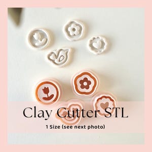 Op de afbeelding: Een verzameling witte en oranje kleisnijders in verschillende bloem- en hartvormen. De afbeelding bevat de tekst "Clay Cutter STL" en "1 Size (see next photo)". Deze snijders zijn ideaal voor knutselen en het maken van decoratieve elementen.