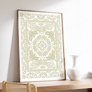 May include: A framed print with a green floral pattern on a white background. The pattern is a repeating design of stylized flowers and leaves.