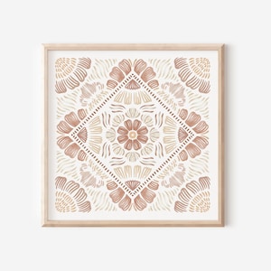 May include: A framed print with a geometric pattern in shades of brown and beige. The pattern features a central flower with four petals and is surrounded by smaller flowers and geometric shapes.