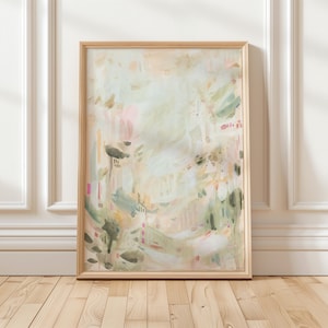 May include: Abstract art print in a light wooden frame. The artwork features a soft, watercolor-style design with pastel colors, including pink, green, and beige. The painting has a dreamy, ethereal quality, with layered brushstrokes and subtle details.