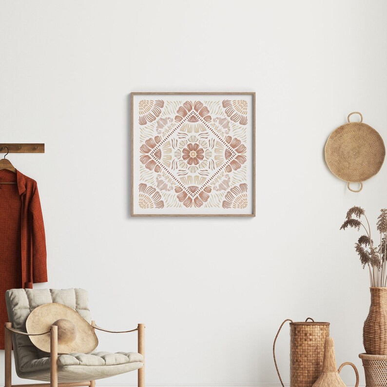May include: A framed print with a geometric design in shades of brown and beige. The design features a central flower motif surrounded by repeating patterns.