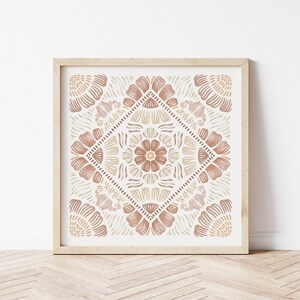 May include: A framed print with a geometric pattern in shades of brown and beige. The pattern features stylized flowers and leaves, creating a symmetrical design.