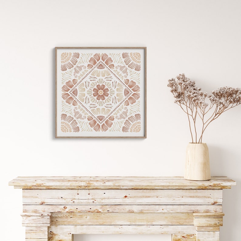 May include: A framed print with a geometric pattern in shades of brown and beige. The print is hanging on a white wall above a rustic wooden mantel.