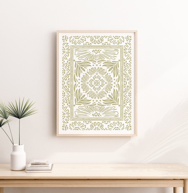 May include: A framed print with a green floral pattern. The pattern is a repeating design of flowers and leaves, creating a symmetrical design.