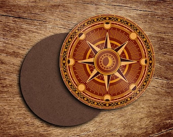 Puede incluir: Un posavasos redondo marrón con un diseño de brújula en tonos marrón y dorado. La brújula presenta una estrella central, fases lunares y patrones geométricos. El texto "dtox creative" está en la parte inferior.
