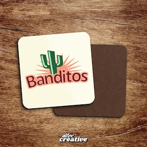 Peut inclure: Deux dessous de verre carrés. L'un a un fond crème avec un cactus vert et un soleil levant, et le mot "Banditos" en rouge. L'autre est marron. Le coin inférieur droit porte la mention "dtox creative".