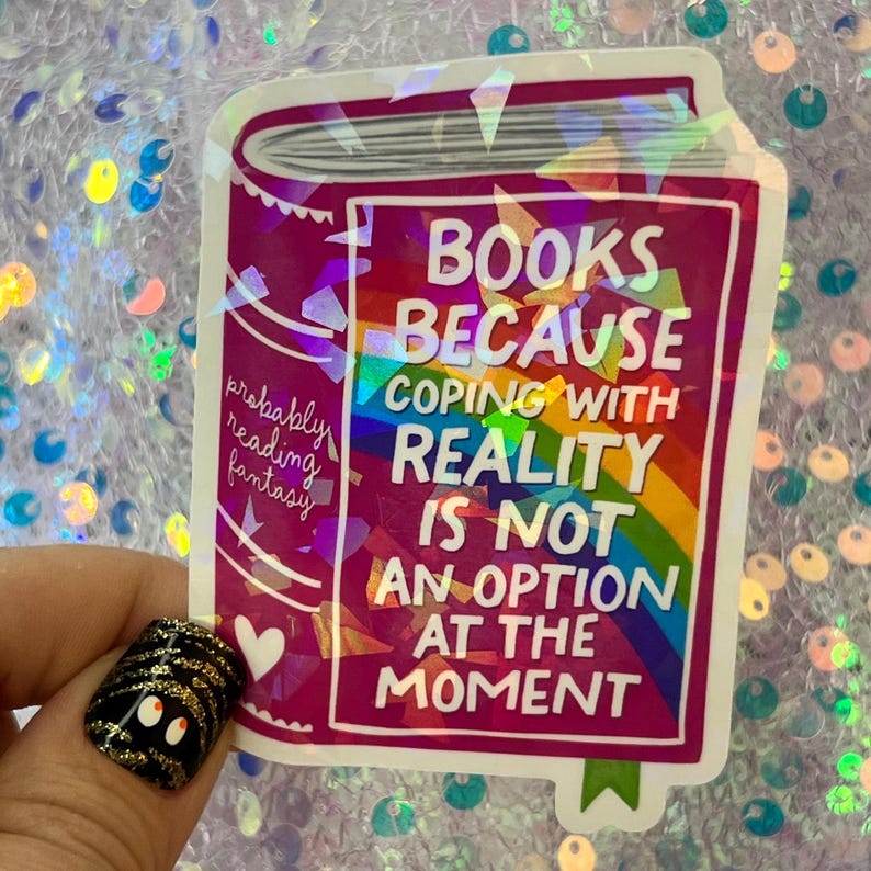 May include: A sticker featuring a stylized book design in shades of pink and purple. The sticker has the text "BOOKS BECAUSE COPING WITH REALITY IS NOT AN OPTION AT THE MOMENT" with a rainbow graphic.