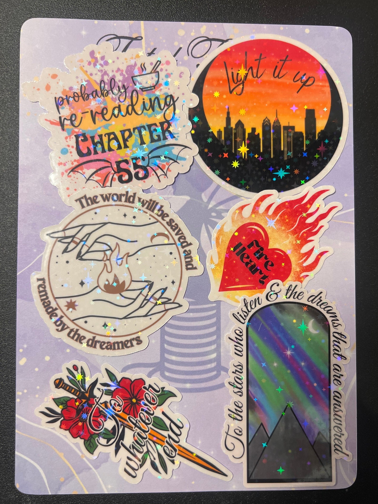 Sparkling holographic stickers of all shapes and sizes, varying colors of red, blue, green, pink, black, and brown.