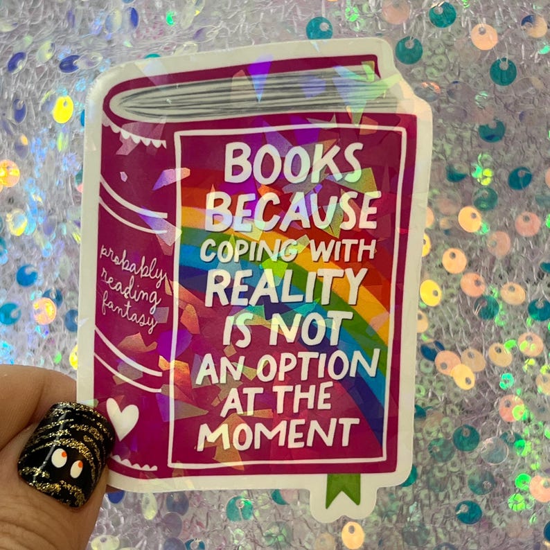 May include: A rectangular sticker in the shape of a book with the text "BOOKS BECAUSE COPING WITH REALITY IS NOT AN OPTION AT THE MOMENT." The sticker has a rainbow background and the words "probably reading fantasy."