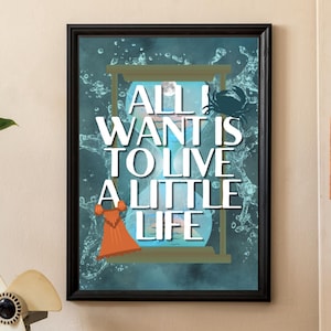 May include: A framed art print with the text "ALL I WANT IS TO LIVE A LITTLE LIFE" in white. The artwork features an hourglass, a crab, and a dress in shades of blue, orange, and white. The print is displayed in a room with plants and a vintage radio.