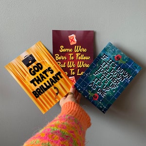 Op de afbeelding: Drie kleurrijke kaarten met inspirerende citaten. De eerste kaart is geel en oranje met de tekst "God That's Brilliant". De tweede kaart is rood met de tekst "Some Were Born To Follow. But We Were Born To Lead". De derde kaart is blauw met de tekst "If it's down, it's down together. If it's up, it's up as one."