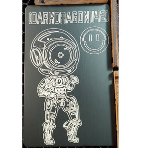 May include: A black and white line drawing of a robot with a large head and a smiley face on a dark grey background. The text "DARKDRAGONII421" is at the top of the image.
