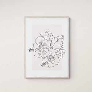 Op de afbeelding: Een zwart-witte lijntekening van een hibiscusbloem met bladeren in een eenvoudige, minimalistische stijl. De tekening is ingelijst en heeft een lichtbeige achtergrond.