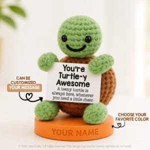 May include: A crocheted turtle figurine with a light green head and limbs and a brown shell, mounted on an orange circular base labelled YOUR NAME. The turtle holds a white sign that reads: You're Turtle-y Awesome. A teeny turtle is always here, whenever you need a little cheer.