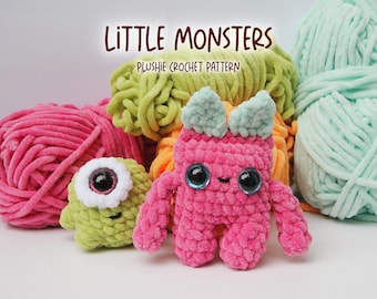 May include: Two crocheted plush toys, one green and one pink, with large eyes. The toys are surrounded by balls of yarn in various colors. The text "LITTLE MONSTERS PLUSHIE CROCHET PATTERN" is at the top of the image.
