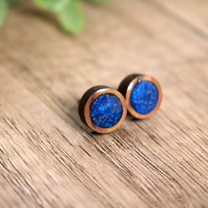 May include: A pair of round wooden earrings with a copper rim and a blue resin inlay.