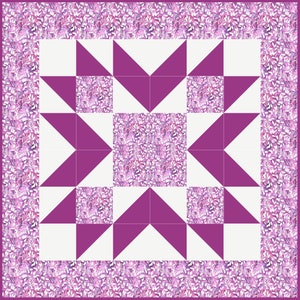 Może przedstawiać: Blok patchworkowy z wzorem gwiazdy w kolorze fioletowym i białym. Środek bloku to kwadrat z wzorem kwiatowym. Blok jest otoczony obramowaniem z kwiatowego materiału.