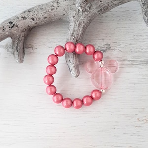 May include: A pink beaded bracelet with a clear plastic Mickey Mouse charm.