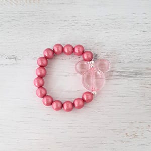 May include: A pink beaded bracelet with a clear pink Mickey Mouse charm.