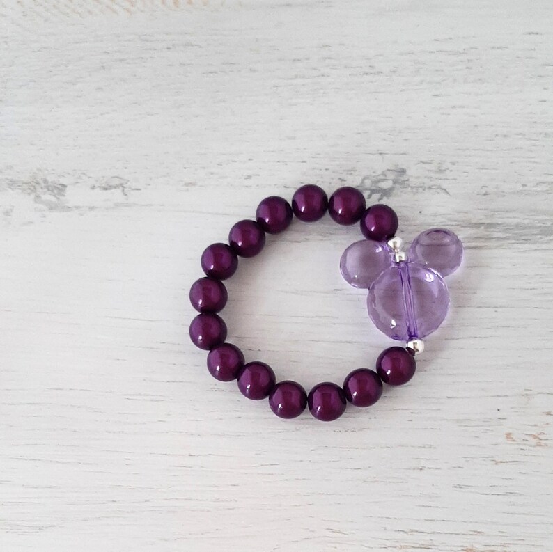 May include: A purple beaded bracelet with a purple Mickey Mouse charm.