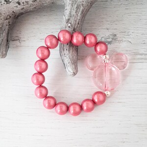 May include: A pink beaded bracelet with a clear pink Mickey Mouse charm.