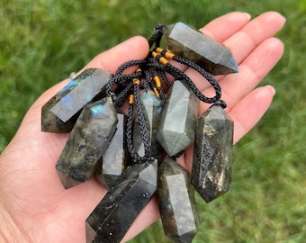 May include: A collection of ten dark green labradorite crystal point pendants with black cords. The pendants are all approximately the same size and shape, and they have a natural, rough finish.