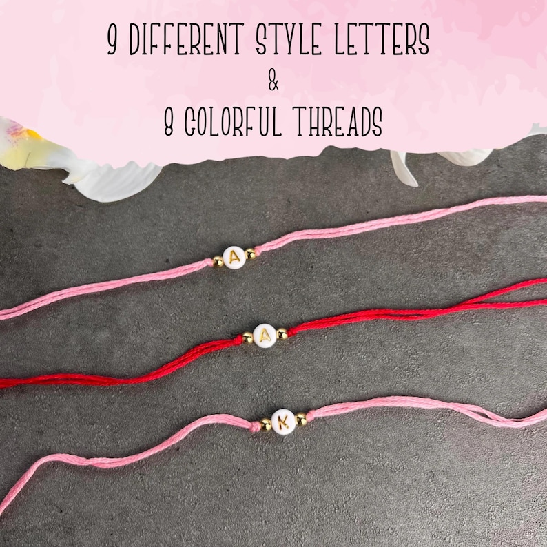 May include: Three bracelets made of thin thread in shades of pink and red. Each bracelet features a single white circular bead with a gold letter, flanked by two small gold-toned metallic beads. The text 9 DIFFERENT STYLE LETTERS & 8 COLORFUL THREADS is visible.