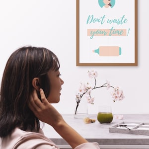 Può includere: Una stampa incorniciata con un'illustrazione di una persona e un pennarello in azzurro e rosa. Il testo sulla stampa recita "Non perdere tempo!"