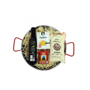 May include: A paella pan filled with a gift set for making paella. The set includes a bottle of olive oil, a box of paella rice, a bag of onions, a can of paprika, and a bag of Bomba rice.