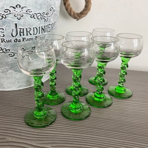 Puede incluir: Juego de seis vasos de cristal transparente con tallo verde retorcido. Los vasos tienen un diseño grabado decorativo.