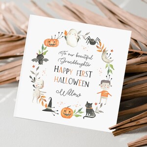 Personalised first Halloween card for baby featuring cute illustrations of pumpkin, ghost, spider, bat, mummy, black cat, and Frankenstein character in autumn colours. Includes custom relation and name with the message ‘Happy First Halloween' Perfect keepsake card for son, daughter, grandson, granddaughter, niece, or nephew celebrating their first spooky season. Printed on quality 300gsm lightly textured cardstock, measures 148 x 148mm and is supplied with a blank recycled kraft envelope.