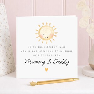 Personalised 2nd birthday card for a girl with cute smiling watercolour sun and little ray of sunshine message, personalised with her name and sender names, a sweet second birthday card for a daughter, granddaughter or special little girl.