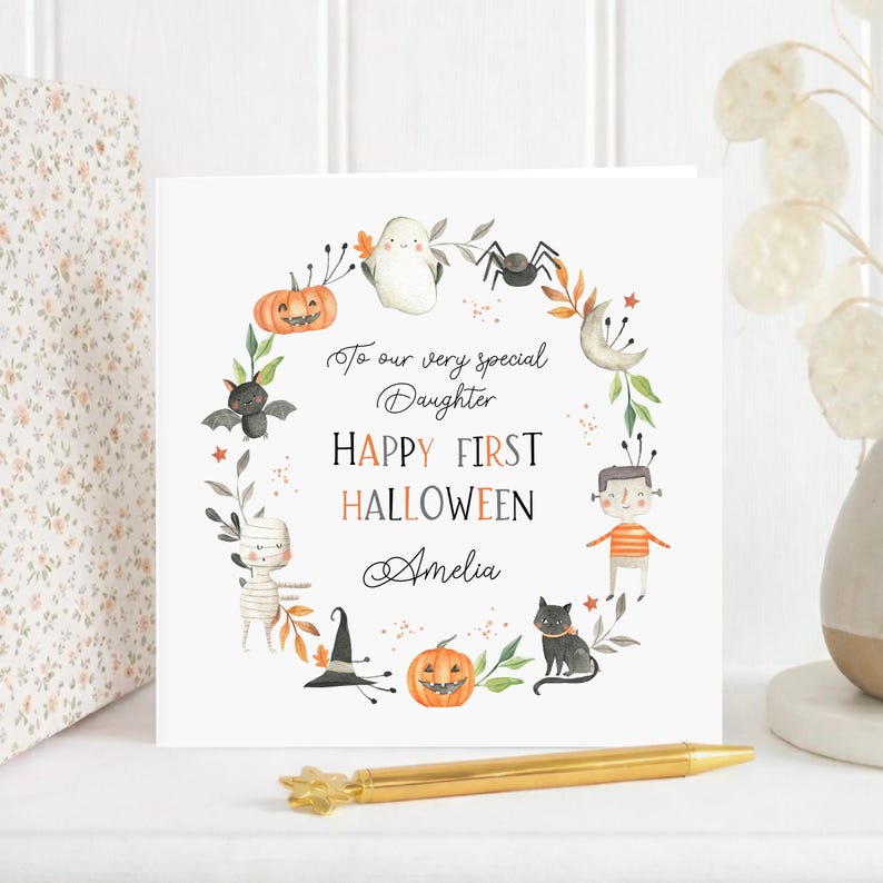 Personalised first Halloween card for a daughter featuring a cute watercolour ghost, pumpkin, bat, mummy, spider, black cat and witch's hat. The card reads Happy First Halloween and is personalised for a very special daughter granddaughter son grandson