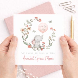 Personalised christening card for baby girl or boy featuring a cute little elephant illustration holding a balloon surrounded by a floral wreath. Perfect keepsake card suitable for christening, baptism, dedication day and more.
Custom name and date, pink or blue options. Printed on quality 300gsm lightly textured cardstock, measures 148 x 148mm and is supplied with a blank recycled kraft envelope.